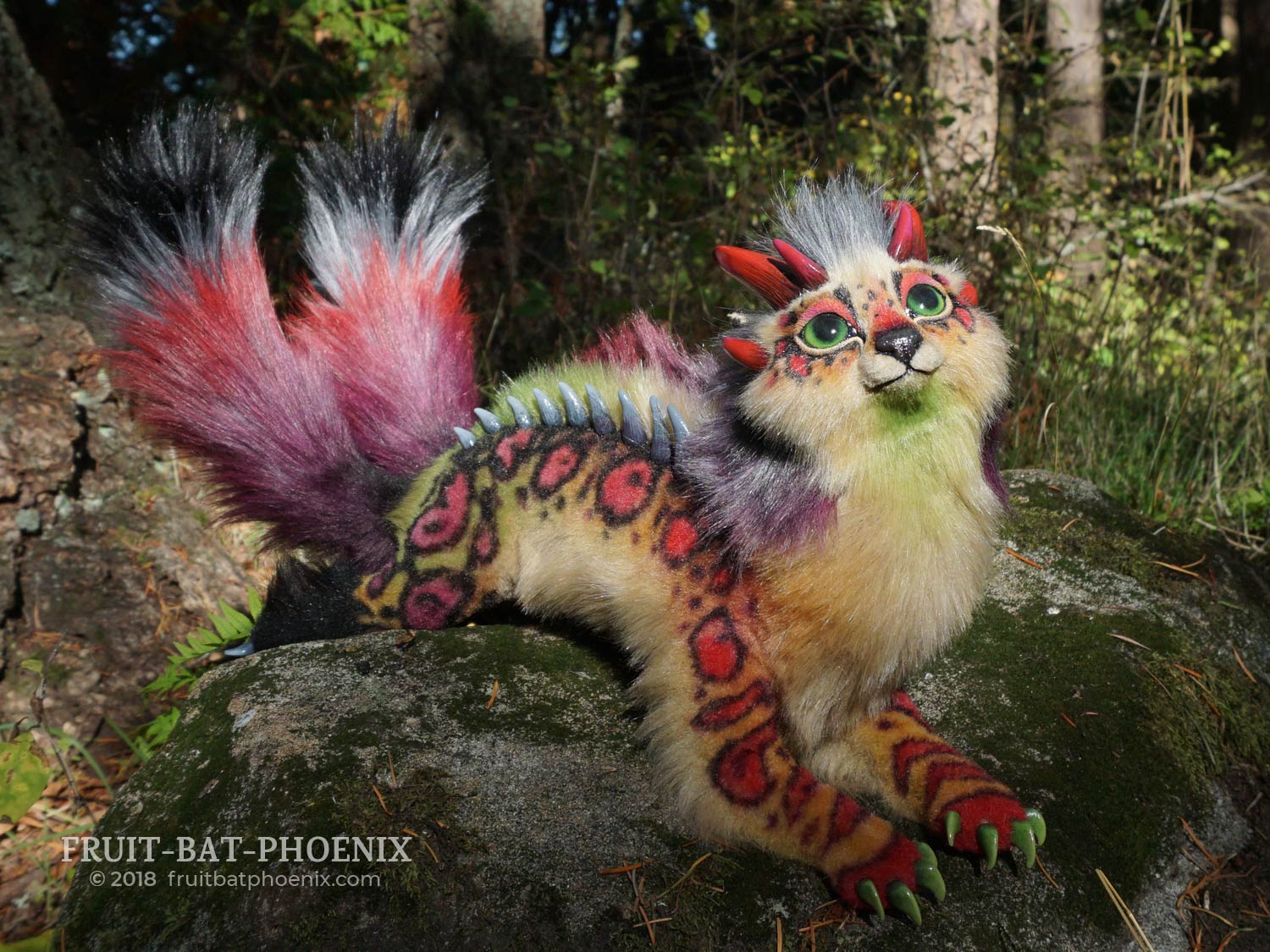 chromatic dragon-cat laying on a rock