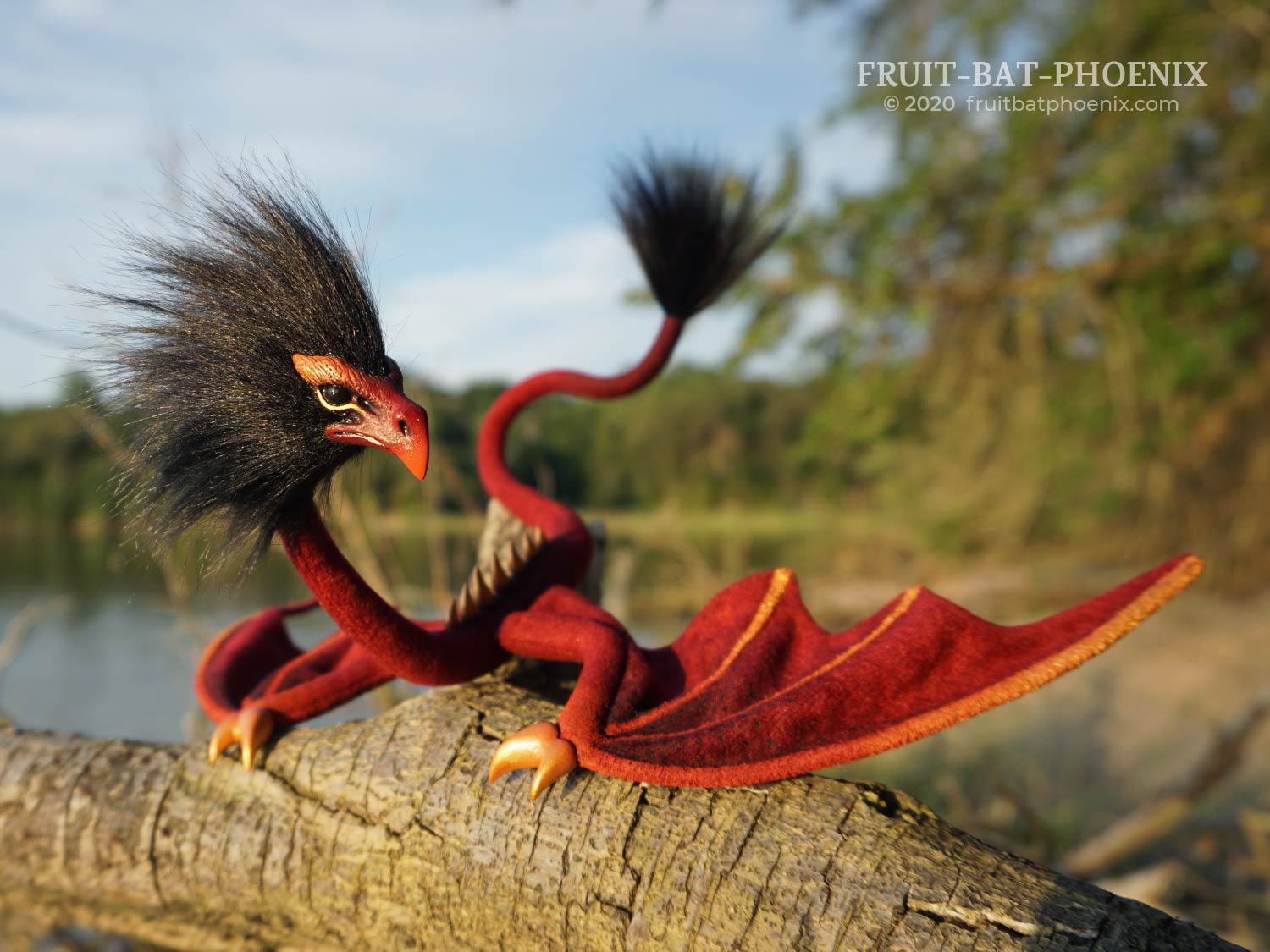 Redgold Eagle Wyrm posable dragon art doll, in front of a beach