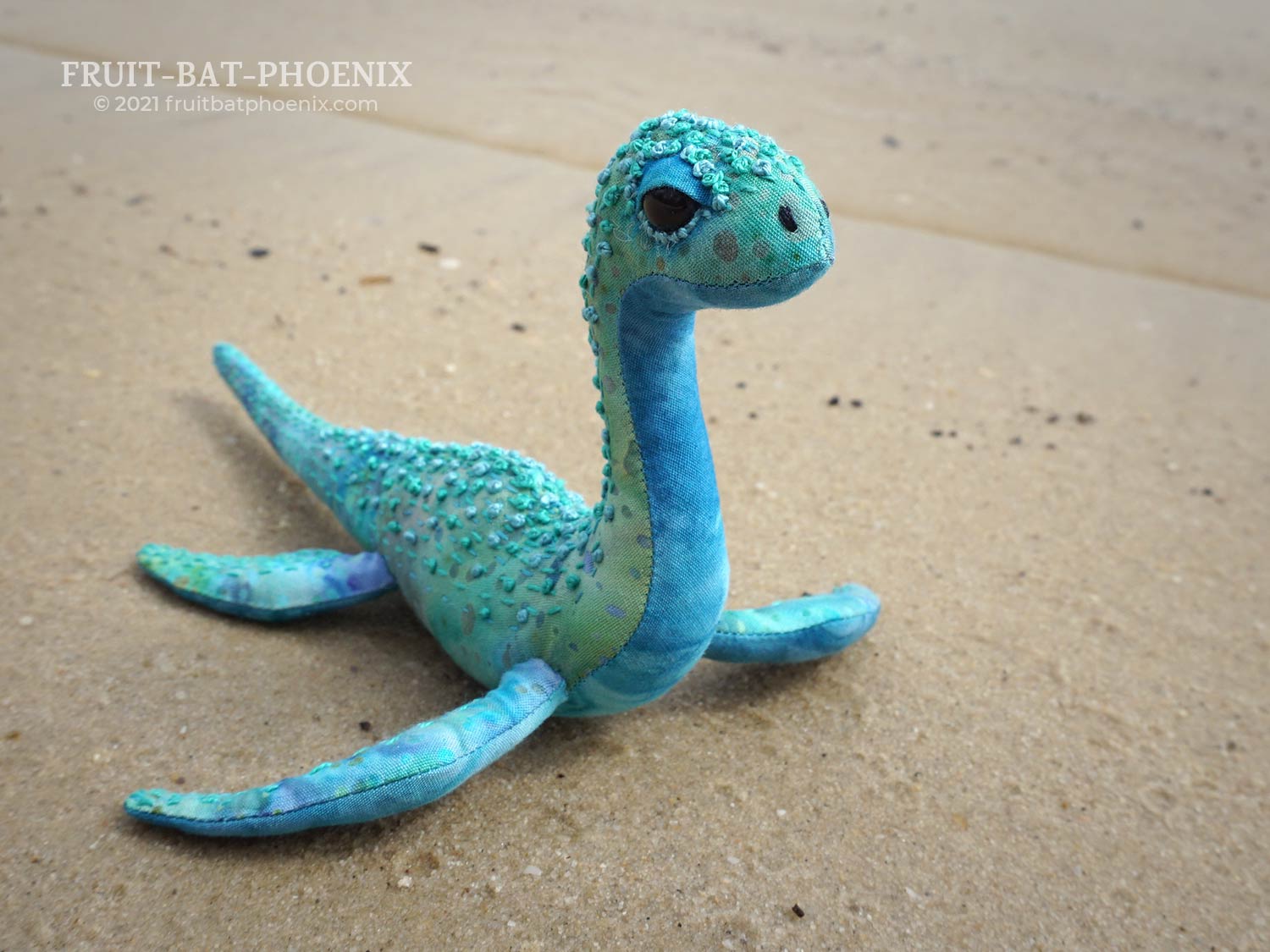 aqua nessilet plush on a beach