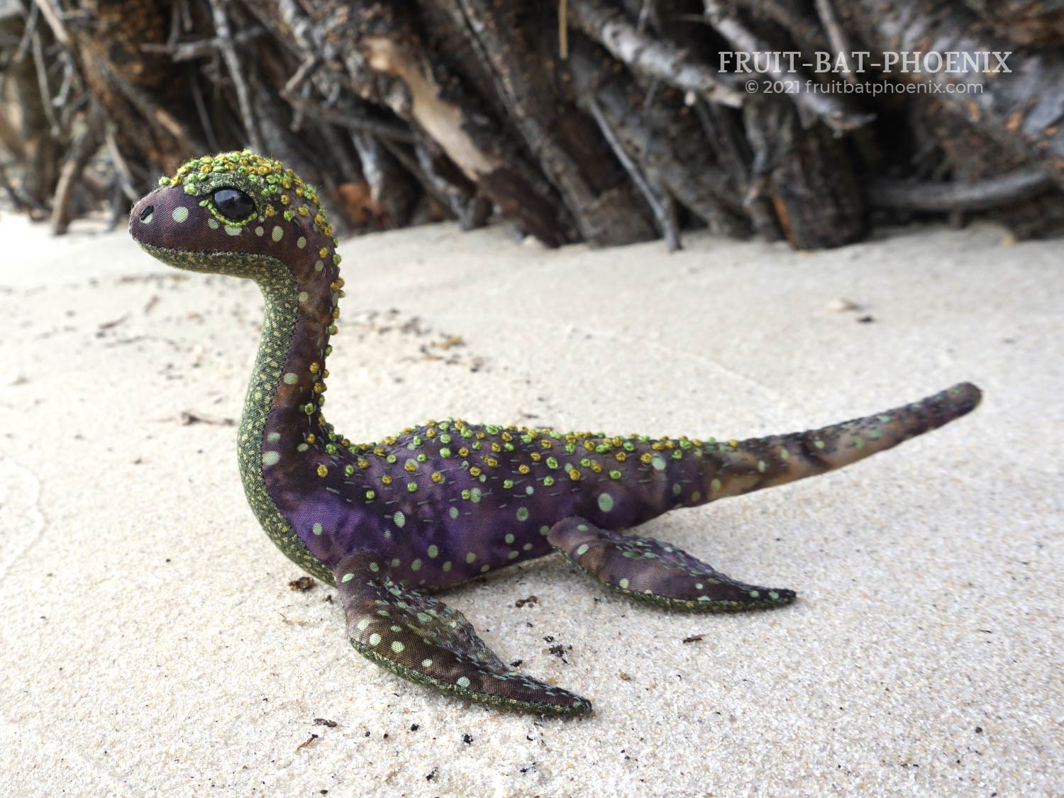 purple-green nessilet plush in front of dense roots